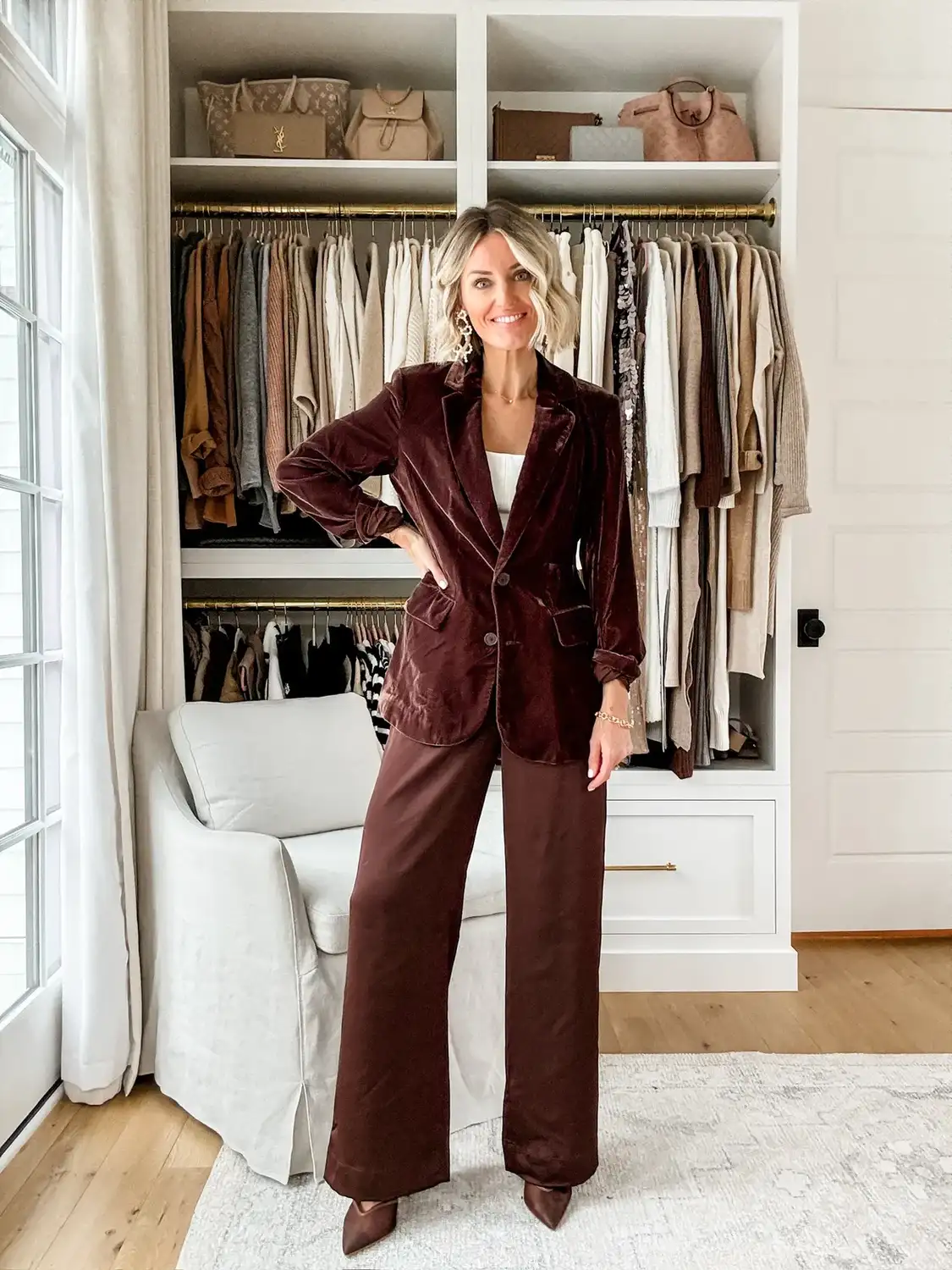 Woman over 40 wearing a chocolate velvet blazer with brown satin wide leg trousers