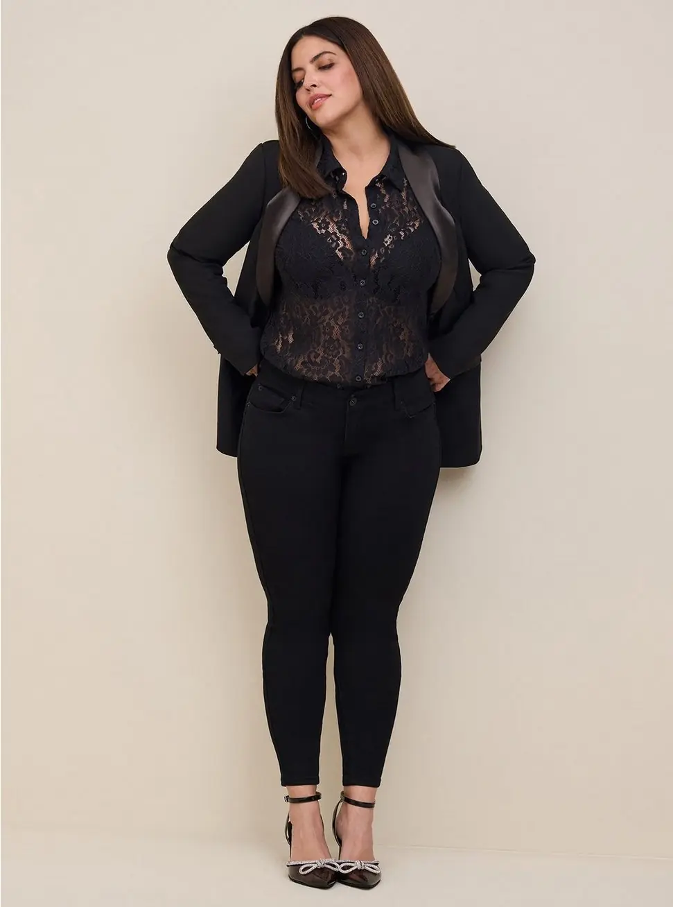 Curvy woman styling a black lace blouse with a blazer and dark jeans for dinner and drinks