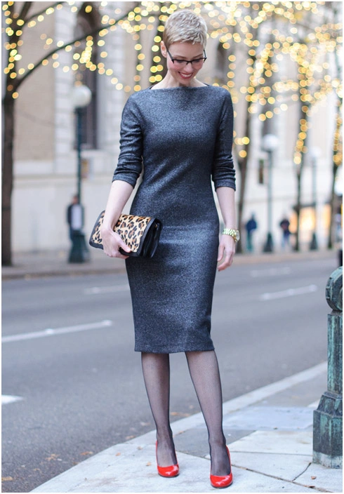 Woman wearing a metallic gray midi dress with a cropped black tuxedo blazer and red pumps