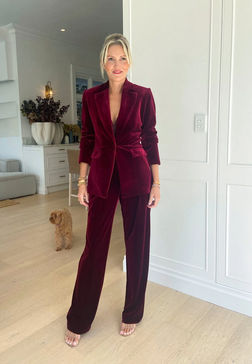Woman wearing a burgundy velvet pantsuit with wide leg trousers for a holiday work event