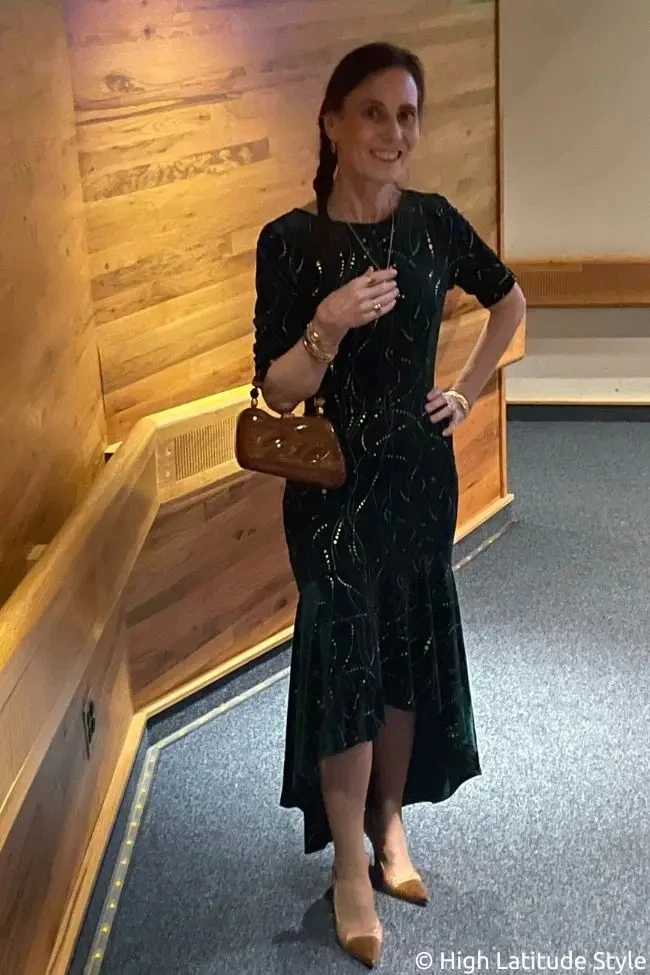 Woman wearing a dark green velvet cocktail dress with tan closed toe pumps for a work party