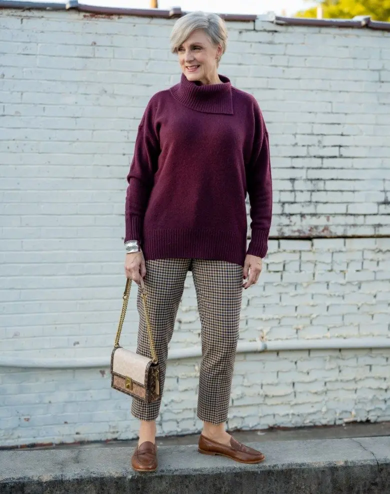 Woman in a burgundy sweater, checked trousers and brown loafers