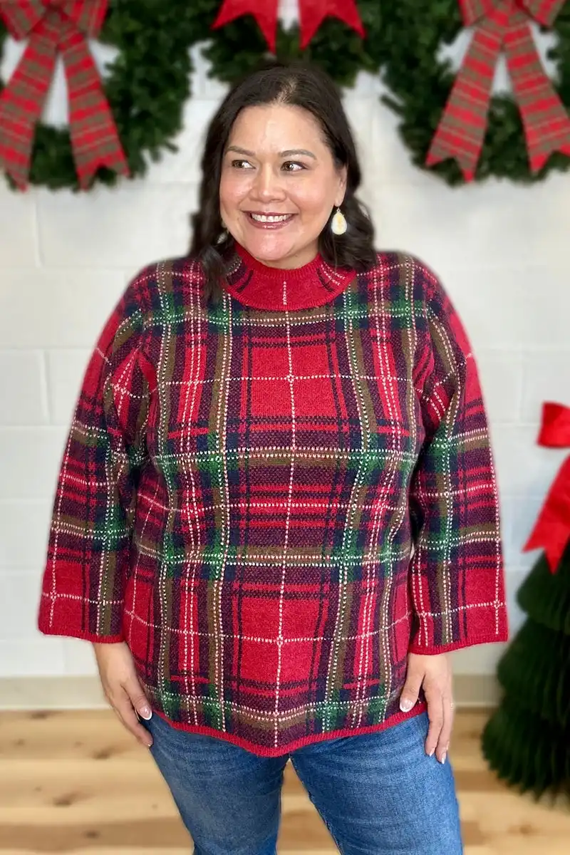 Midsize woman wearing a red plaid mock neck sweater with classic blue jeans