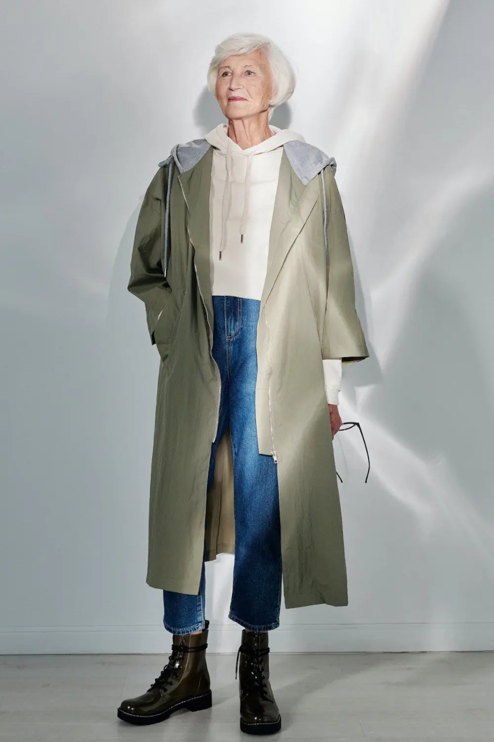 Mature woman in an olive weatherproof coat with straight jeans and winter boots