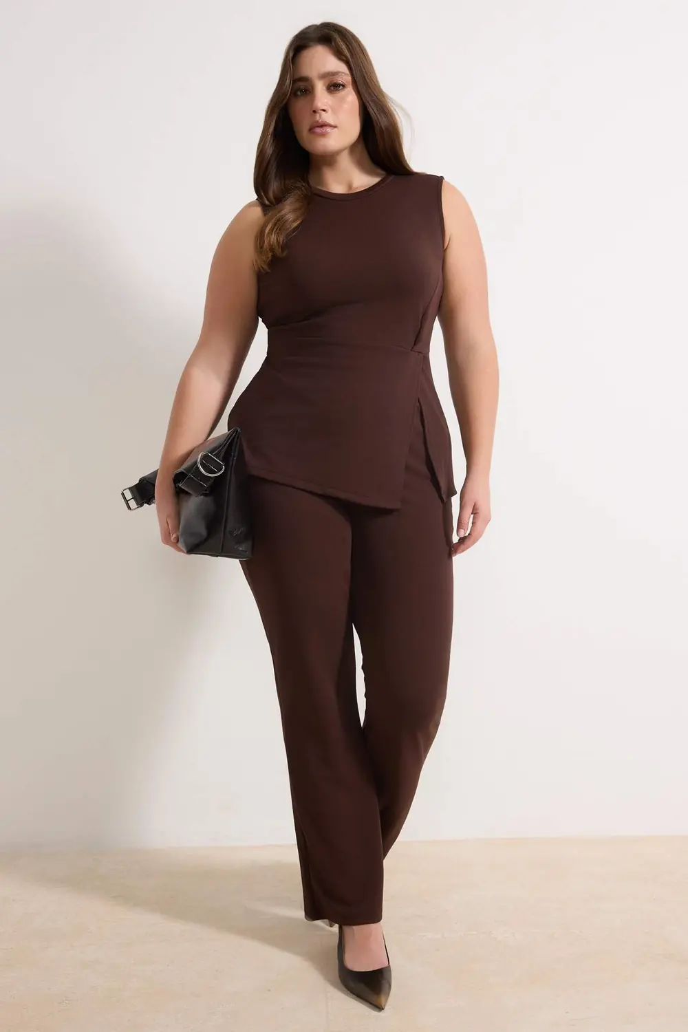 Midsize woman wearing a chocolate brown matching knit top and trousers for winter drinks