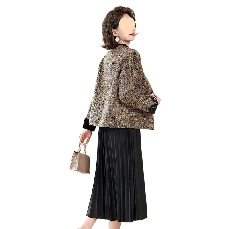 Mature woman wearing a multicolor tweed jacket over a black pleated midi dress