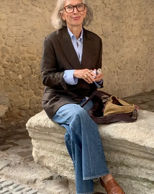 Woman over 50 styling wide leg jeans with a blazer and loafers in winter